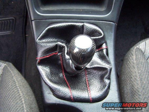 Gear shifter with carbon fiber knob and black leather boot with red stitching