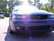 2003 Ford Mustang - Front view of a blue 2003 Ford Mustang Cobra parked outdoors with another vehicle behind it.