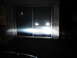 1995 Ford Thunderbird - Bright headlights illuminate a dark scene, reflecting off a glass door. The Supermotors.net logo is visible in the corner.