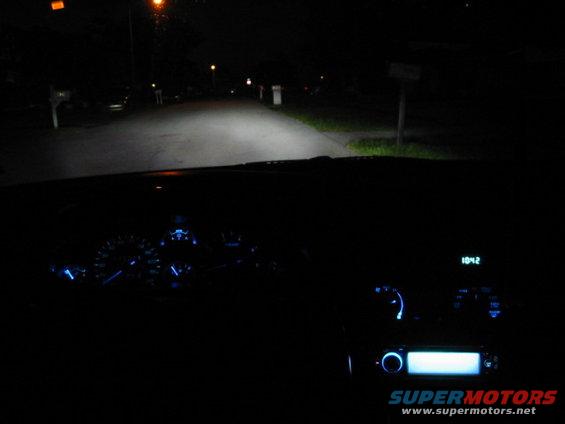 Car interior at night, dashboard gauges and radio display illuminated