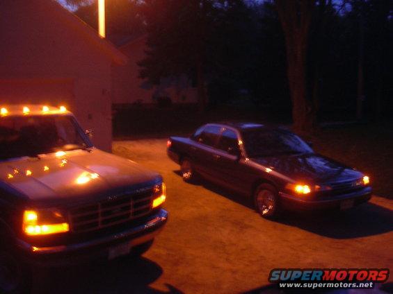 Dark sedan parked next to a pickup truck at dusk
