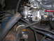 1978 Ford F-250 - A close-up view of an engine's carburetor and fuel filter assembly, showing various hoses and mechanical components.
