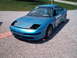 1993 Ford Probe - This blue car appears to be a modified vehicle, possibly for racing, with visible roll cage and missing headlights.