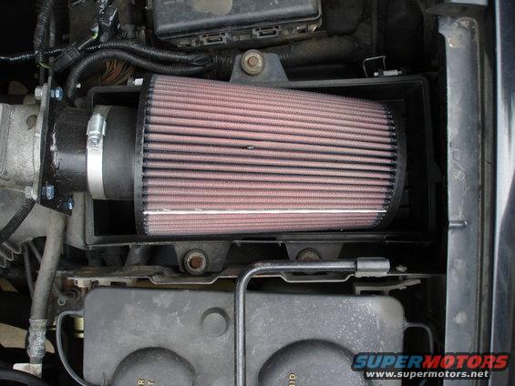 Aftermarket engine air intake filter installed in a vehicle's engine bay