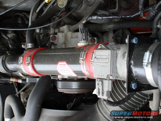 Engine intake tube with red clamps and a "STOP" sticker, connected to a mass airflow sensor