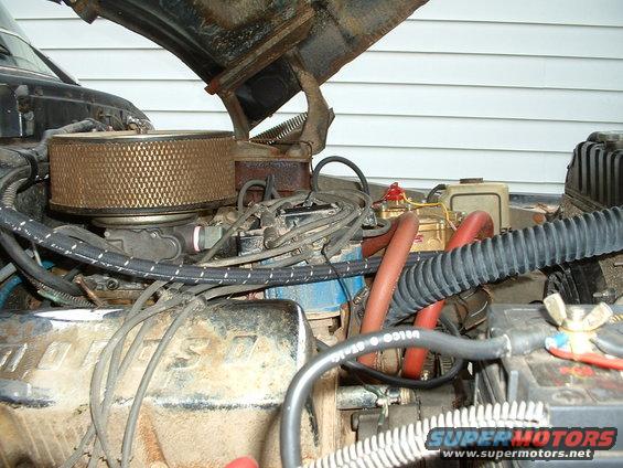 Engine bay with air filter, carburetor, and wiring visible