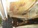 1984 Ford Bronco - The underside of the vehicle shows significant rust and wear on the frame and suspension parts.