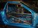 1993 Ford Probe - Interior of a blue car stripped down and fitted with a roll cage.