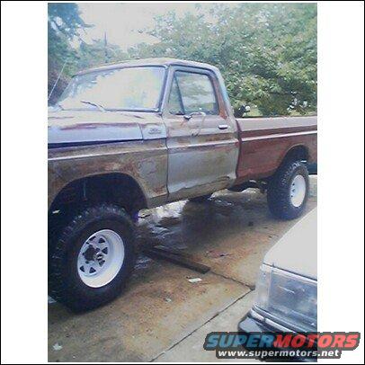 Side view of a rusty 1979 Ford F-150 pickup truck with white wheels