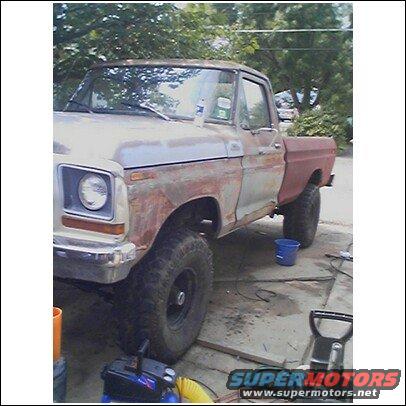 1979 Ford F-150 pickup truck with rust and primer, lifted suspension