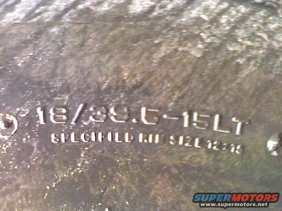 Close-up of tire sidewall with markings like 18/39.0-15LT and SPECIFIED IN. SIZE 12-15