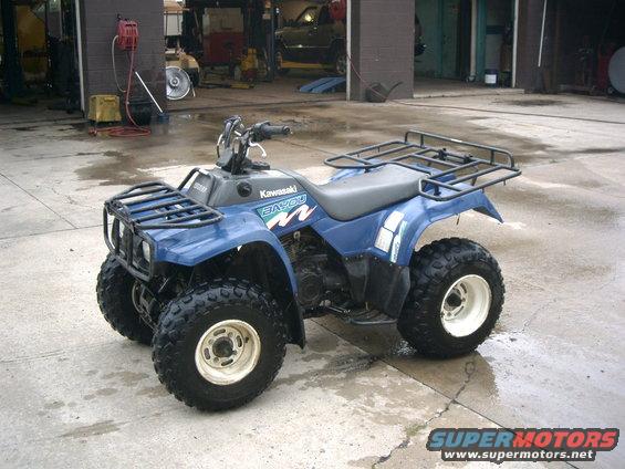 Blue Kawasaki Bayou ATV parked in a garage