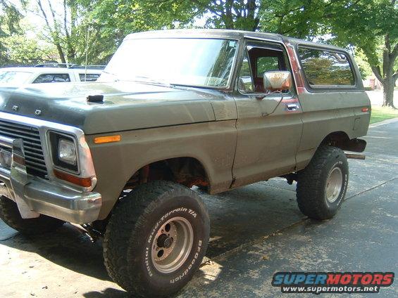 Olive green 1978 Ford Bronco with aftermarket wheels and tires, viewed from the front three-quarter angle