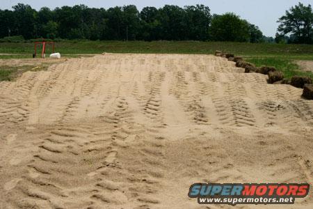 Sand track with tire marks and SuperMotors logo