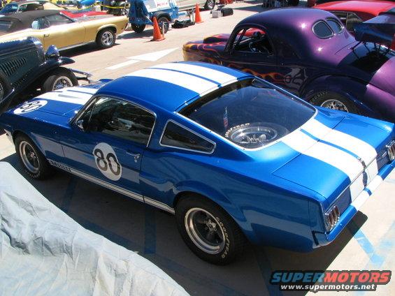 Blue 1966 Ford Mustang coupe with white racing stripes and number 80 on door