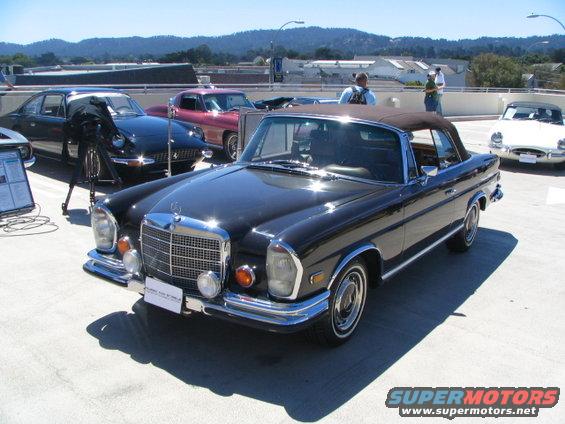 black convertible Mercedes-Benz parked, other cars and people in background