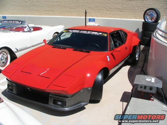 Red sports car with wide fenders and a dark gray front bumper with Ford logos