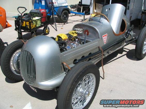 Silver vintage race car with exposed engine and wire wheels. Boyle Valve logo visible on side