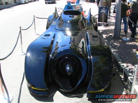 Black custom car with a large central intake and finned fenders, viewed from the front