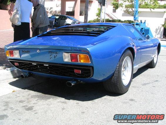 Rear view of blue Lamborghini Miura SV with louvred engine cover and quad exhaust pipes