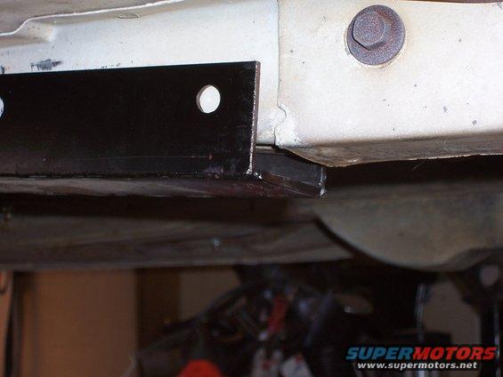 Underbody frame with black metal bracket and bolt