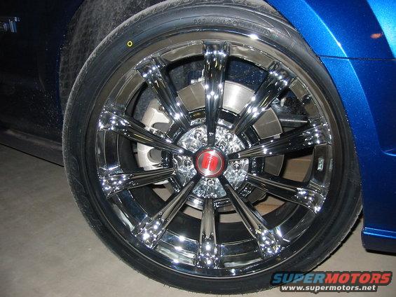 Blue car's chrome wheel with a red center cap and tire