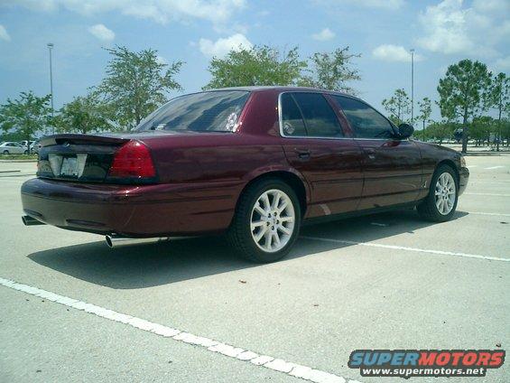 2004 Ford Crown Victoria, maroon, rear 3/4 view, white rims, spoiler