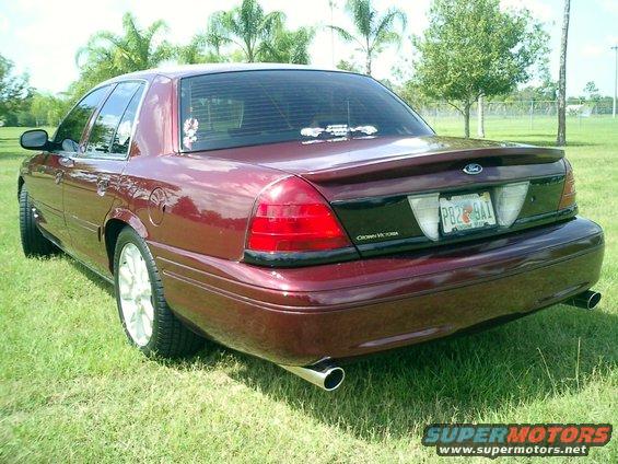 Maroon 2004 Ford Crown Victoria rear view with custom spoiler and chrome exhaust tips
