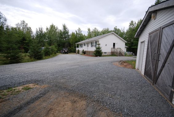 Jeep Wrangler parked in driveway near house and garage
