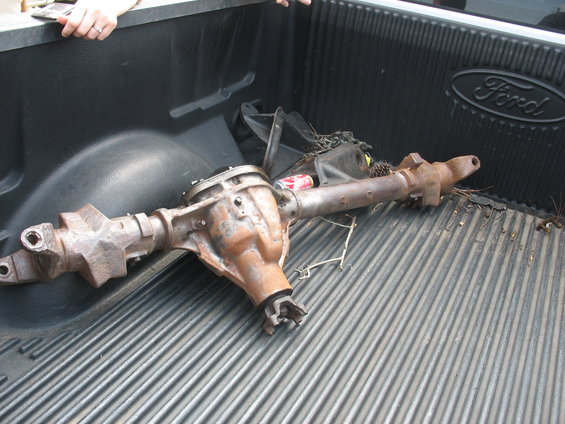 Rusty rear axle assembly in a Ford truck bed