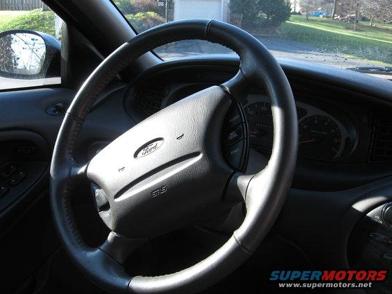 1999 Ford Taurus interior showing steering wheel, dashboard, and side mirror