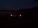 1994 Ford Probe - A car sits by the water at night with its headlights illuminated.