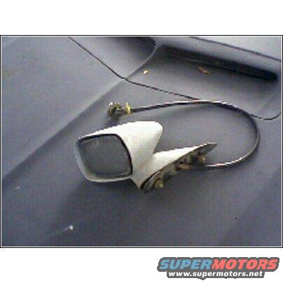 White side mirror assembly with cable resting on a dark surface