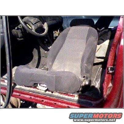 Interior shot of a car seat and steering wheel, red door frame visible