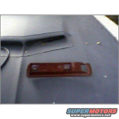 Brown car part with two clear lenses on a grey surface