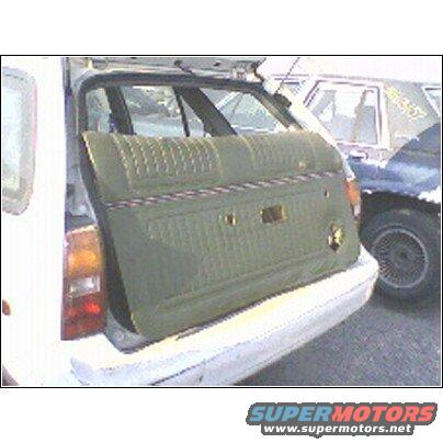 Green car door panel with horizontal pleats and a chrome strip, resting on a white car's bumper