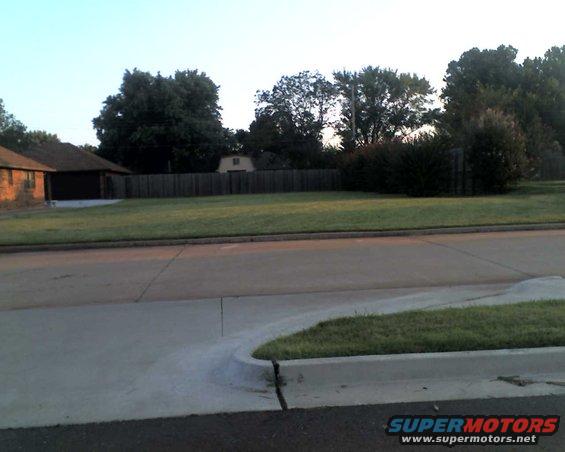 Suburban street scene with houses and trees under a clear sky