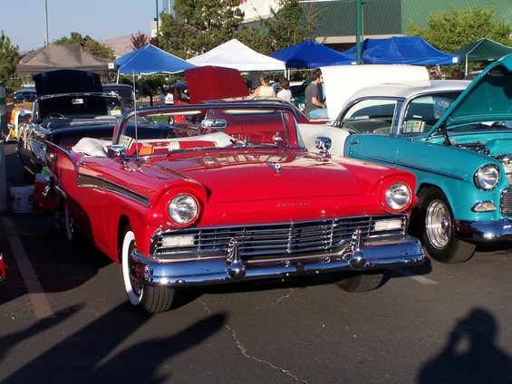 Red 1957 Ford Fairlane convertible parked next to a teal car