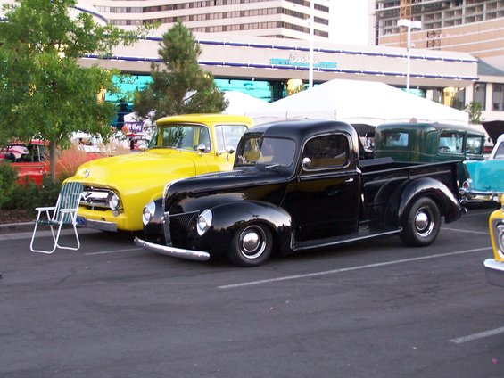 Black pickup truck parked next to a yellow truck