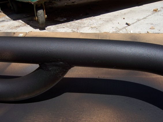 black metal tube with a curved section welded to it