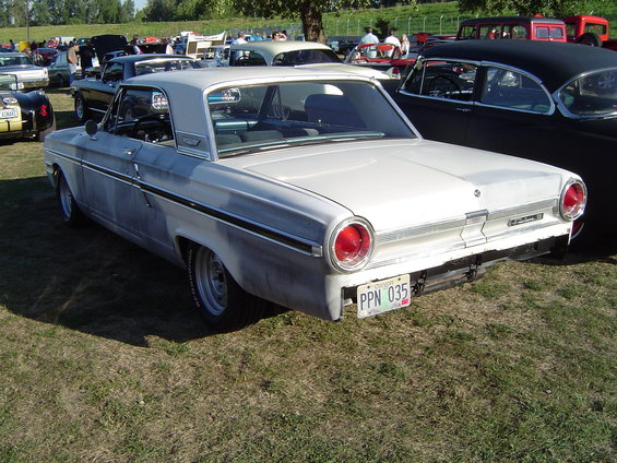 White 1963 Ford Falcon, rear view, parked on grass with other cars