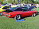 1964 Ford Fairlane - A red and black 1969 Chevrolet Camaro is displayed at an outdoor car show.