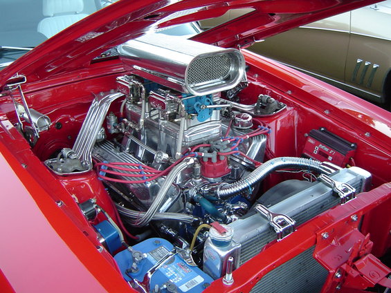 Red engine bay with chrome air intake and blue battery