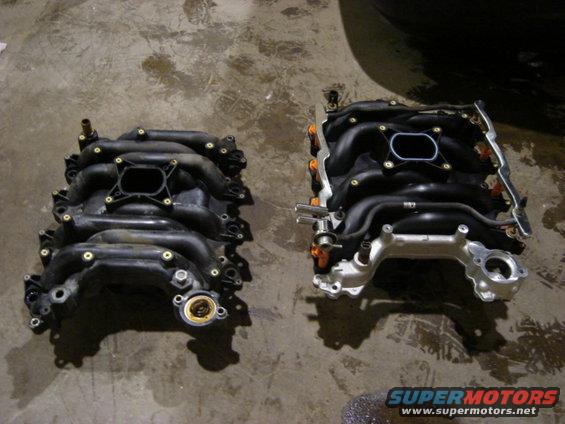 Two black plastic intake manifolds with silver metal components and orange fuel injectors on a concrete floor