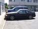 1989 Ford Mustang - Side view of a black 1989 Ford Mustang parked next to a blue SUV.