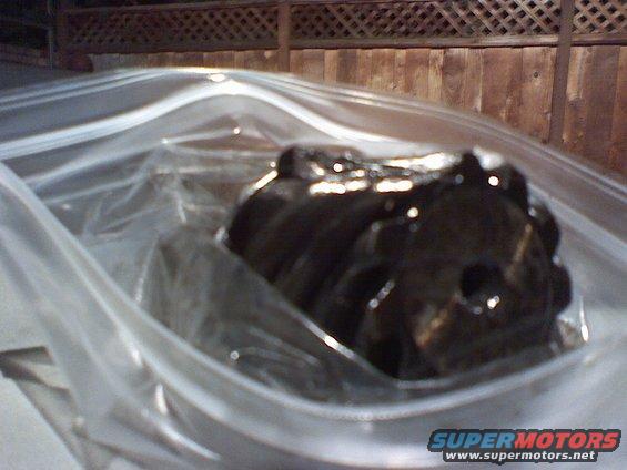 Dark engine component inside a clear plastic bag