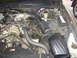 2000 Ford Crown Victoria - Engine bay of a 2000 Ford Crown Victoria, showing the air intake system and alternator.