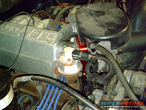 Close-up of engine parts including intake manifold, fuel pressure regulator, and spark plug wires