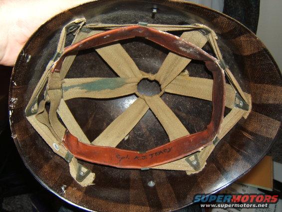Interior of a helmet with fabric straps and leather headband. Text 'Cpl. K.J. TRACY' is written on the headband