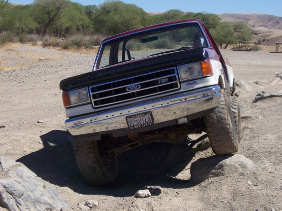 Ford F-series truck on rocky terrain. Front grille has Ford logo. License plate reads 22SX148